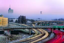 Roads against pink sky and headlight from cars