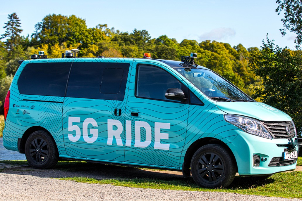 Photo from the side of the blue 5G Ride minibus with cameras on the roof